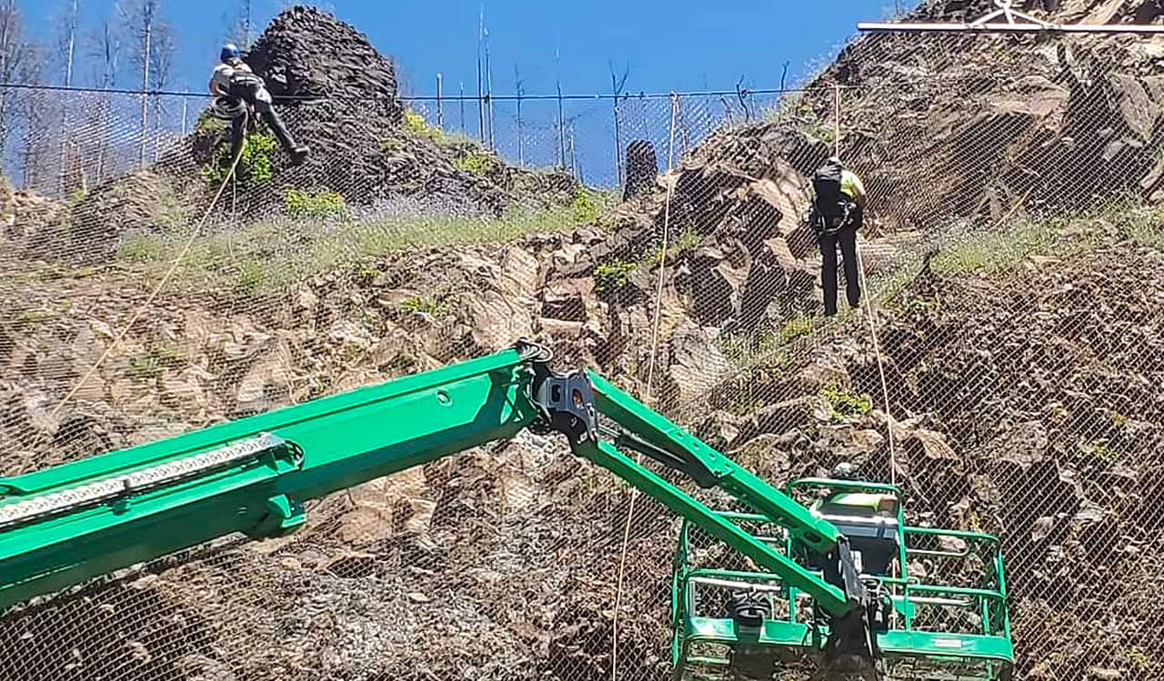 A photo of a crane and workers installing Attenuator mesh