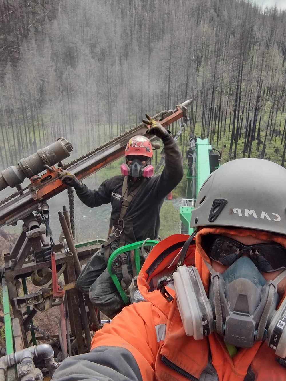 A photo of two trained workers using a remote access drill for rock mitigation