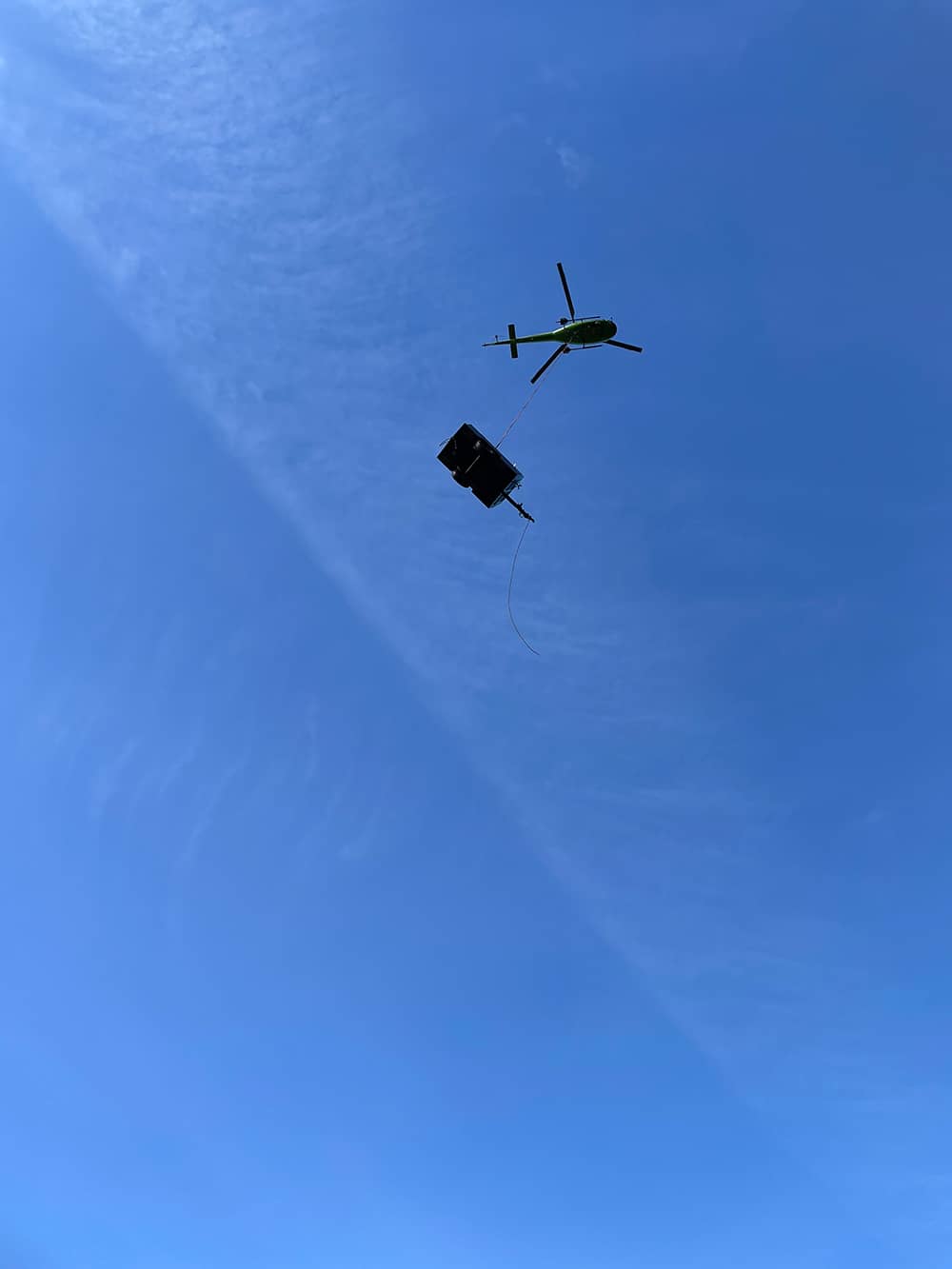 A photo of a helicopter transporting equipment for a remote access drill operation