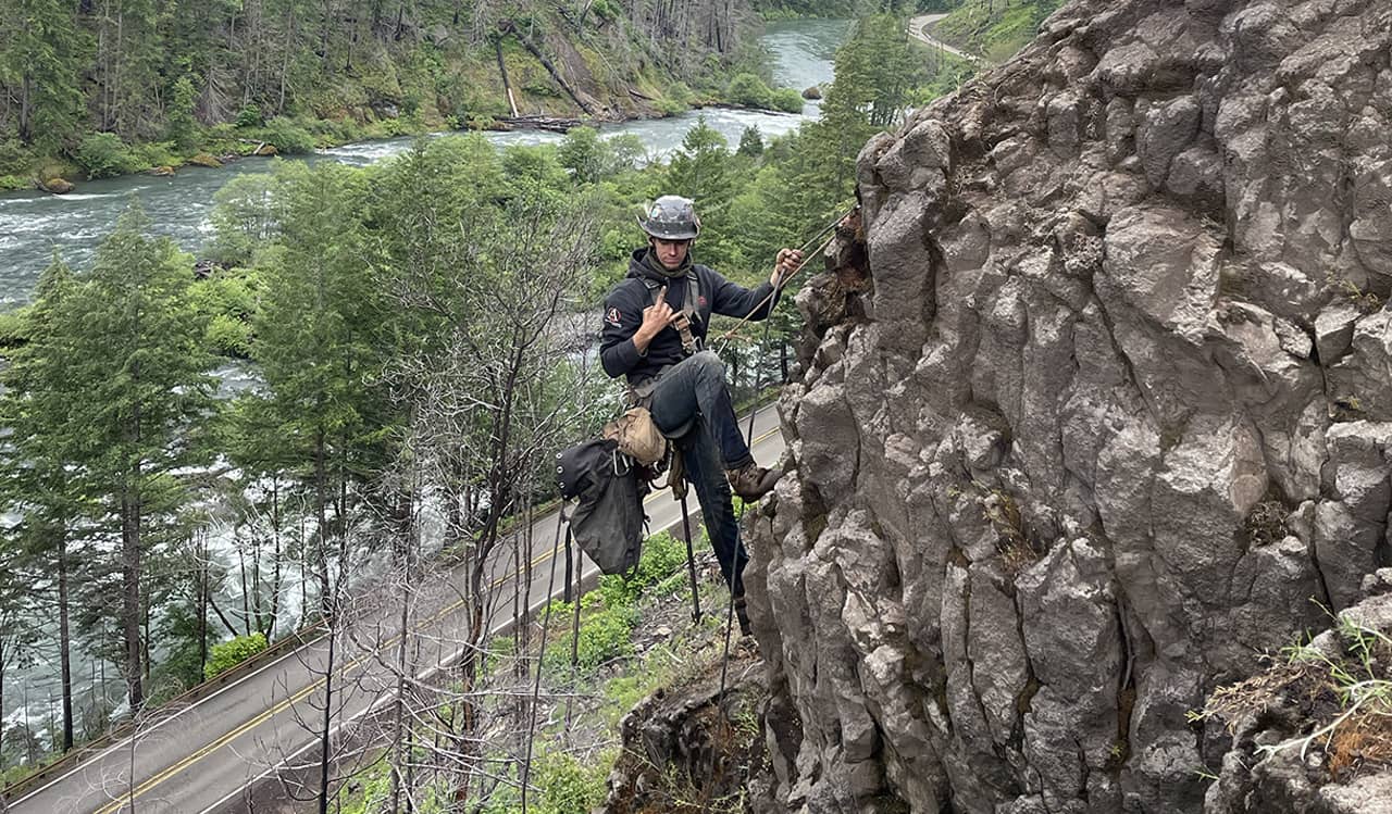 A photo of a professional scaler on a rock out cropping